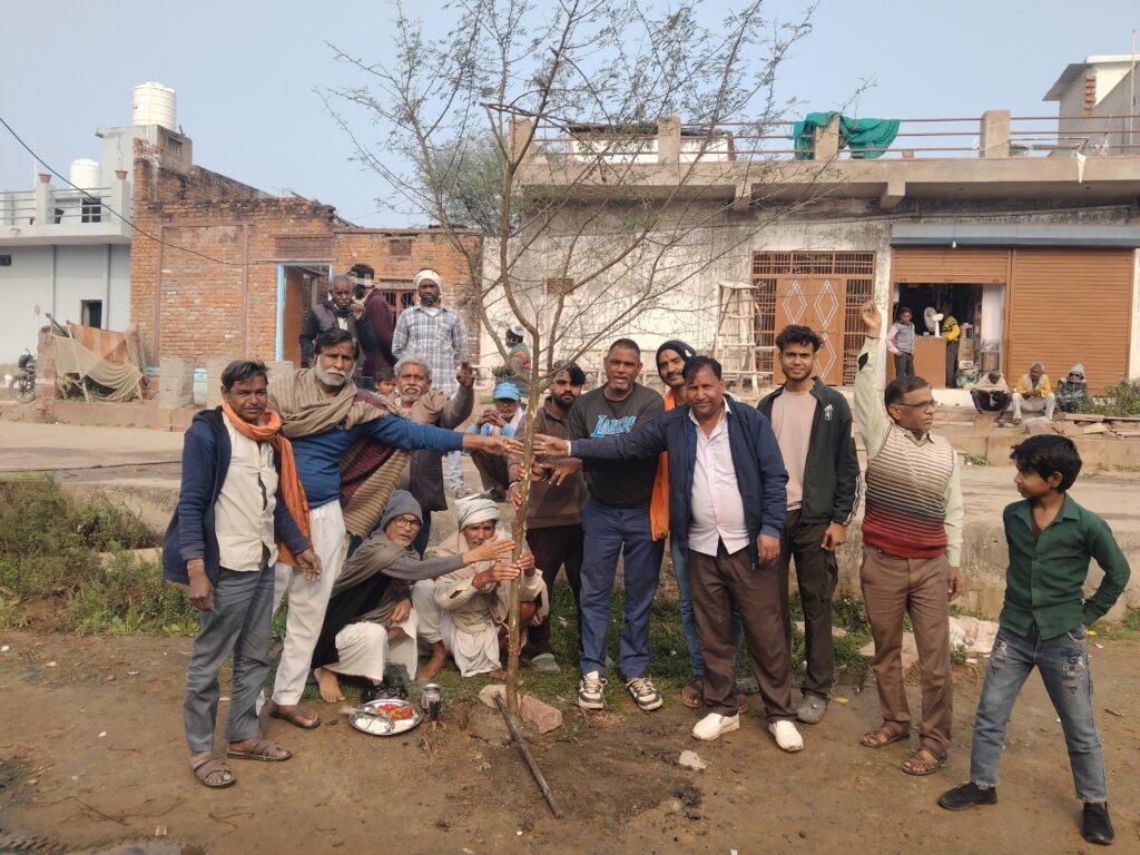 Village men gathered together planting Holi Ka Danda stick in the ground marking 37 days before Holi in Haryana