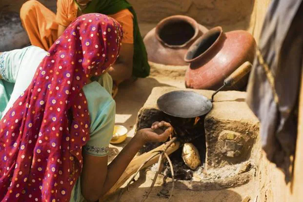 Haryanvi woman cooking on traditional chulha during Festivals of Haryana