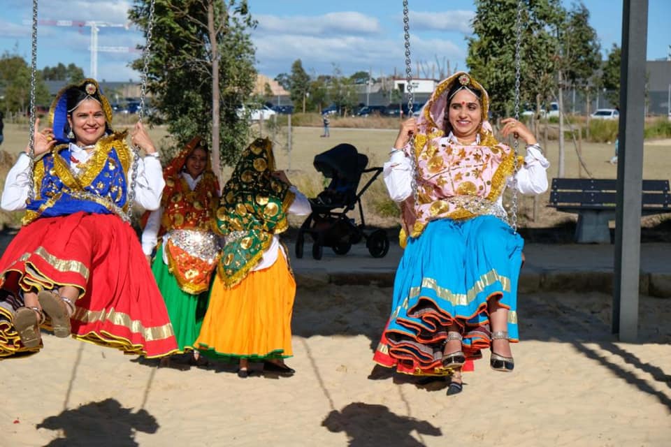 Women in traditional Haryanvi dress celebrating Teej festival on swings