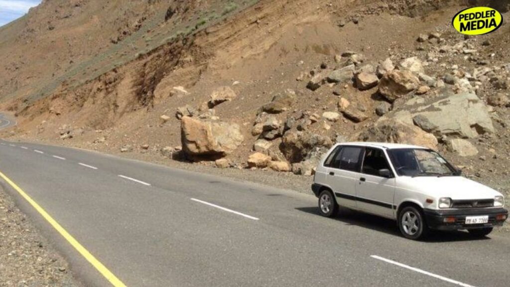 White 1997 Maruti 800 from Punjab driving on Leh highway through barren rocky Ladakh landscape