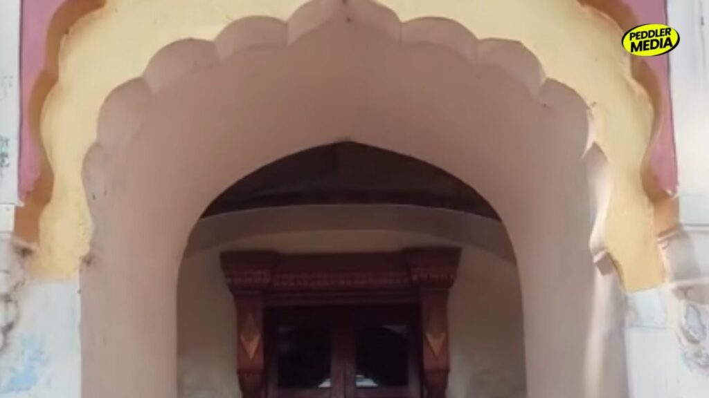 Arched entrance gateway of a traditional Haryana Chaupal with carved wooden door