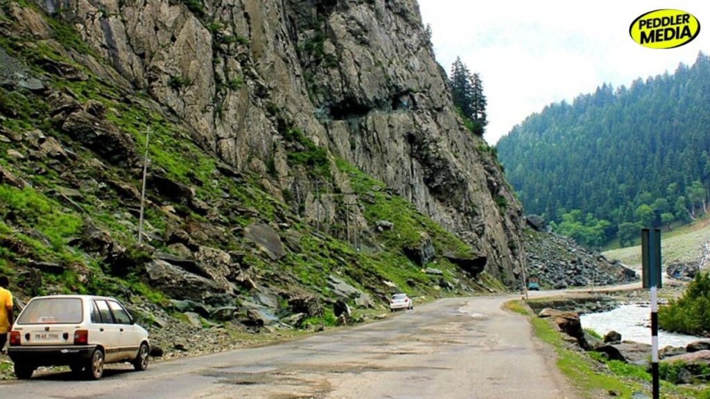 1997 Maruti 800 PB 43 7700 on narrow mountain road with rocky cliffs and river during Chandigarh to Leh trip