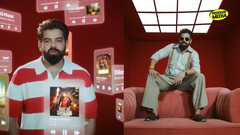 Masoom Sharma sitting confidently in red room wearing suspenders and sunglasses