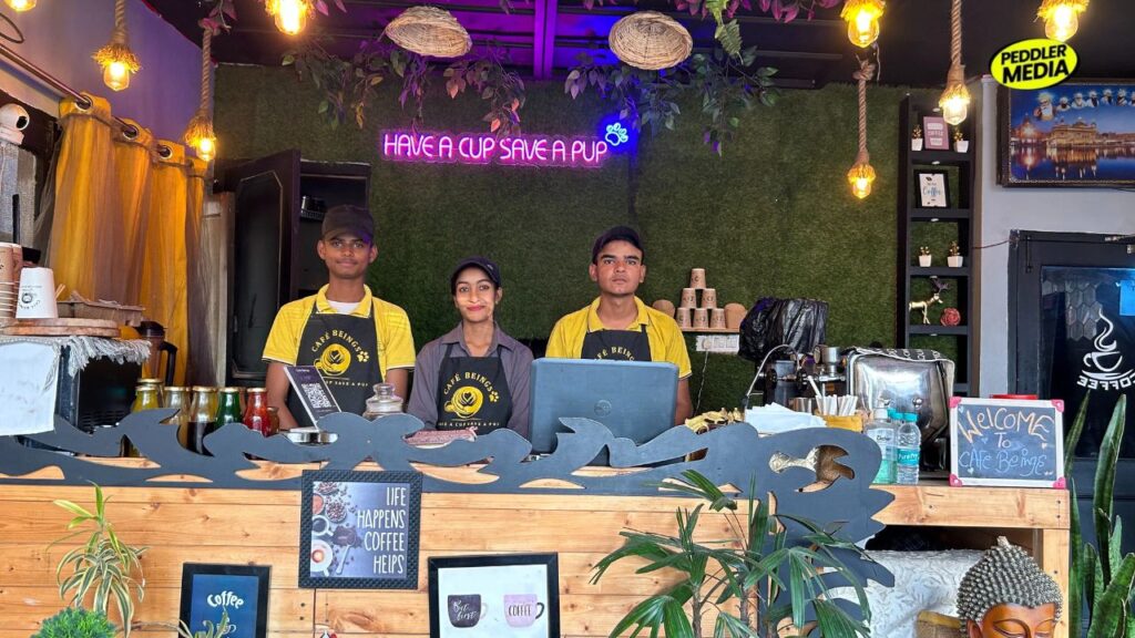 Cafe Beings Ambala interior with Have a Cup Save a Pup neon sign