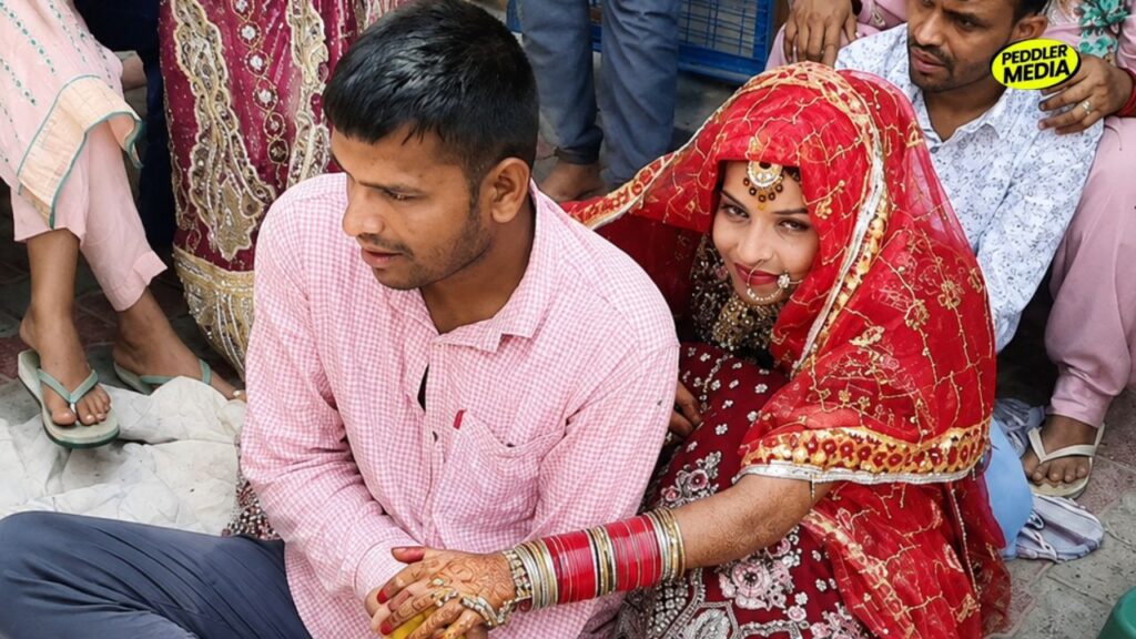 Bride and groom seated together with family during Dever Ki God ritual at a Haryanvi wedding