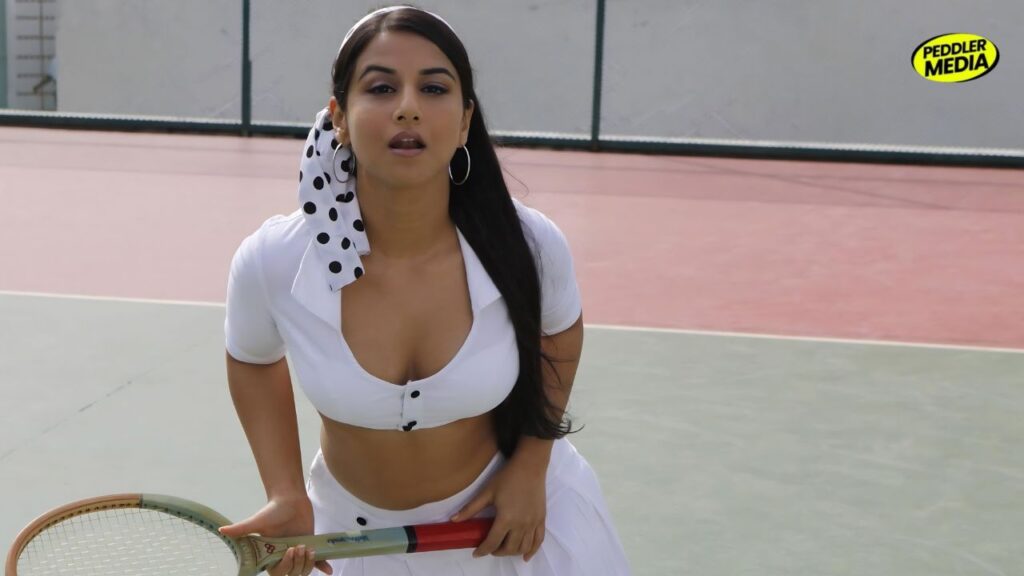 Vidya Balan in a white outfit posing with a tennis racket