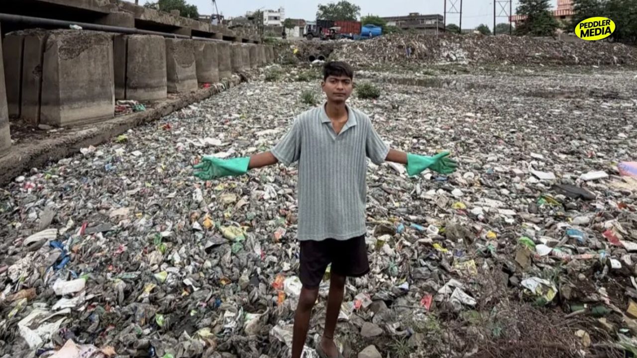 Bittu Tabahi stands in a heavily polluted stretch of Ajnar River surrounded by plastic and waste in Biaora, Madhya Pradesh
