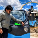 Sumit Prajapati looking at his blue vehicle during his historic e-rickshaw to Spiti Valley tour.