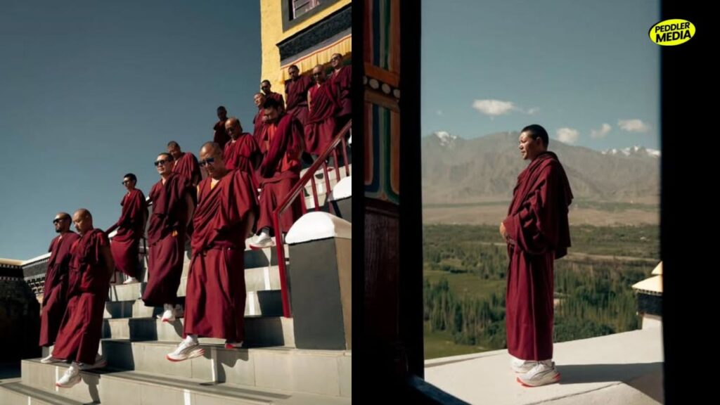 Buddhist monks in maroon robes wearing PUMA sneakers walk down monastery steps in Leh, Ladakh