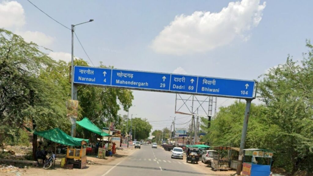 A state highway SH-17 signboard to explore Haryana showing road distances to Narnaul, Mahendergarh, Dadri, and Bhiwani.