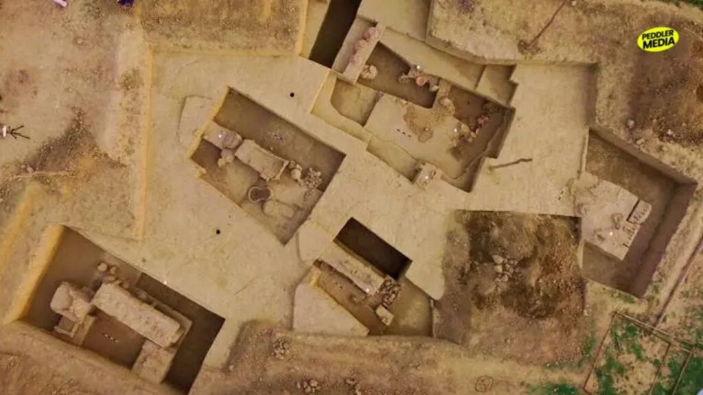 Top-down aerial view of structured archaeological excavation pits and ancient house wall foundations in Rakhigarhi Haryana.
