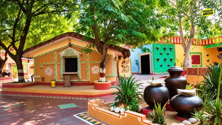 A colourful traditional village courtyard showing mud houses and clay pots representing the heritage style of Mhari Mati Agro Tourism Hisar.
