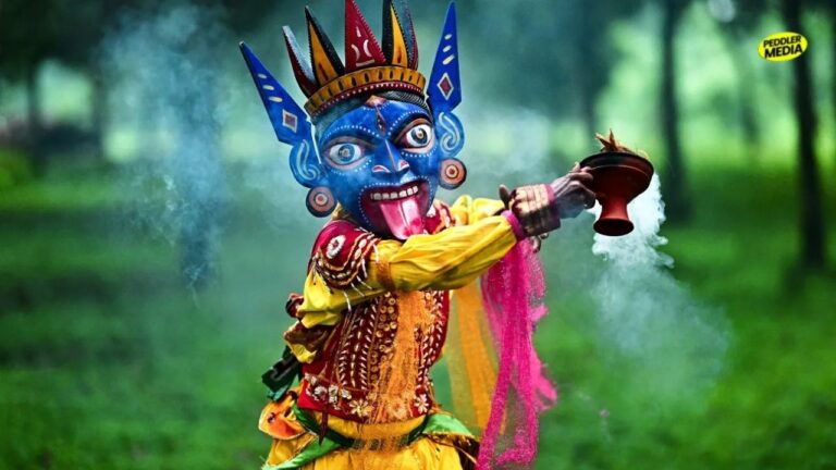 A performer wearing a traditional fierce blue deity mask and vibrant attire holding a smoking dhunuchi burner during a cultural event, representing the Bengali community's traditions.