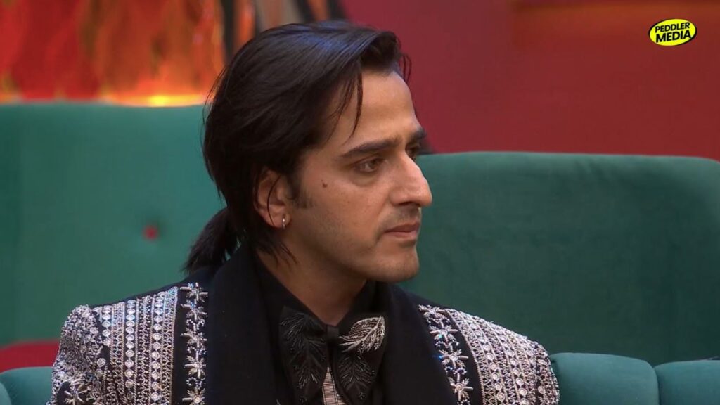 • Qazi Touqeer looking emotional and serious while sitting on a sofa inside the Bigg Boss house.